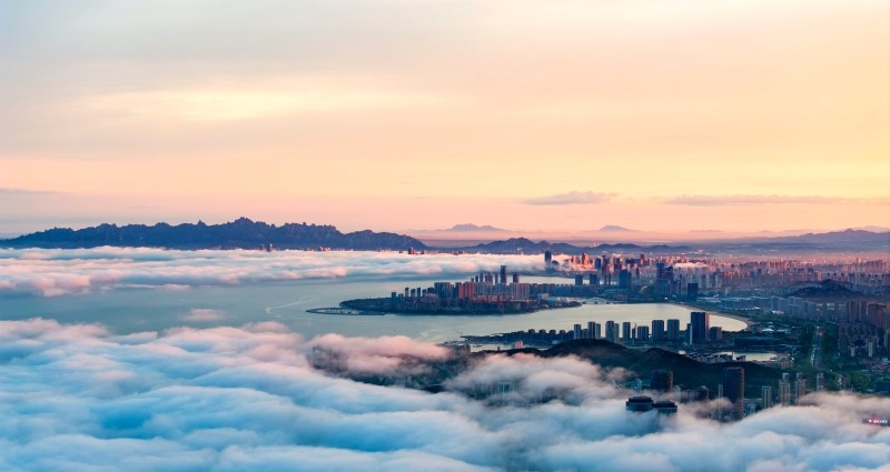 Clouds rise at Lingshan Bay where sunset glow envelops