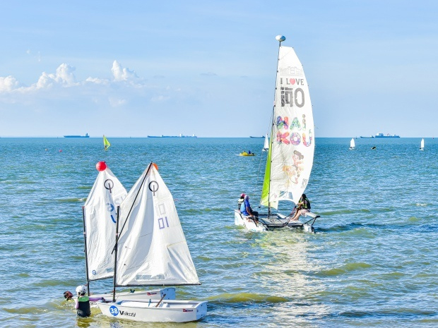 Tourists go windsurfing at sea in Haikou