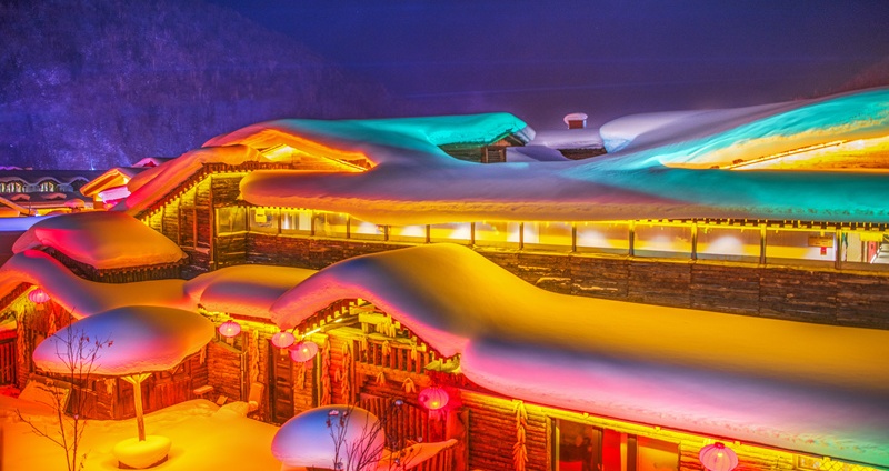 White snow covers the snow town, reflecting dreamlike colorful lights