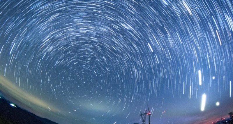 A starry sky unfolds above the wind farm