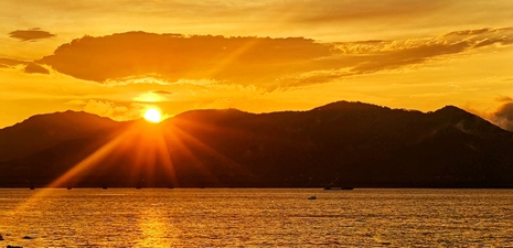 The Qiantang River is bathed in the glow of golden sunset clouds